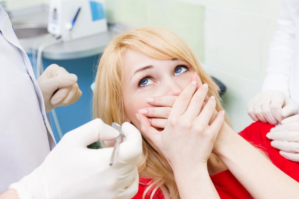 woman hiding her mouth with hand from fear of the dentist