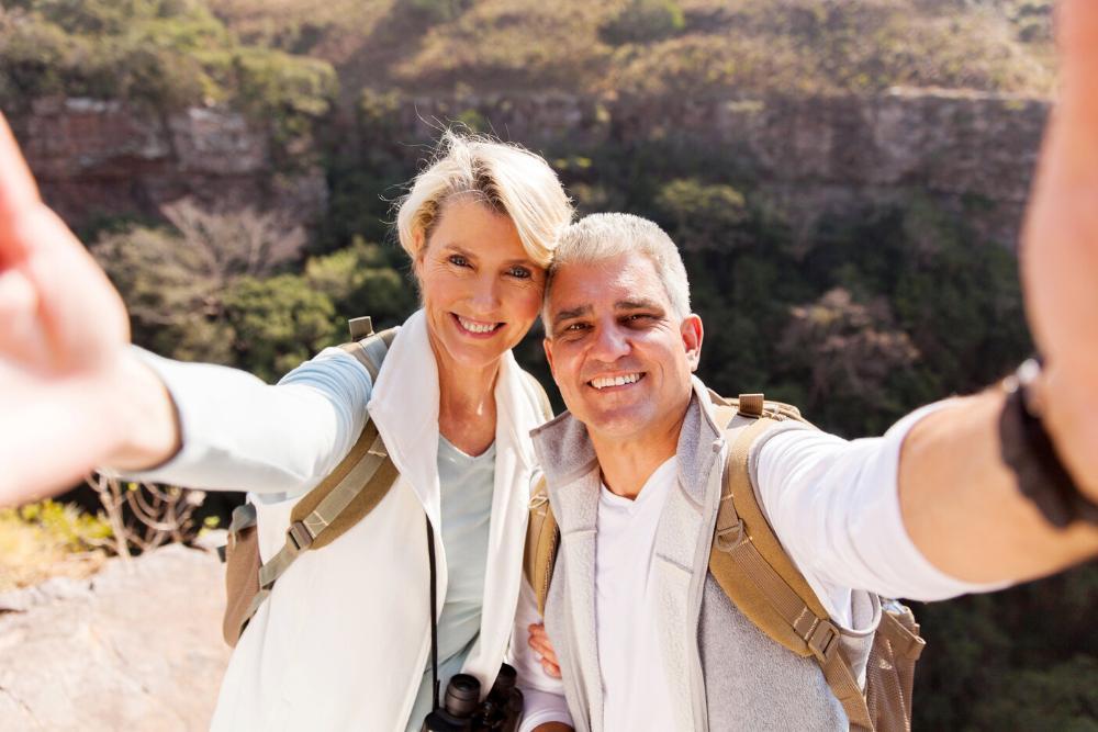 older man and woman taking selfi on a hike