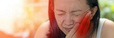 woman holding jaw during an acute Periodontitis Flare-Up