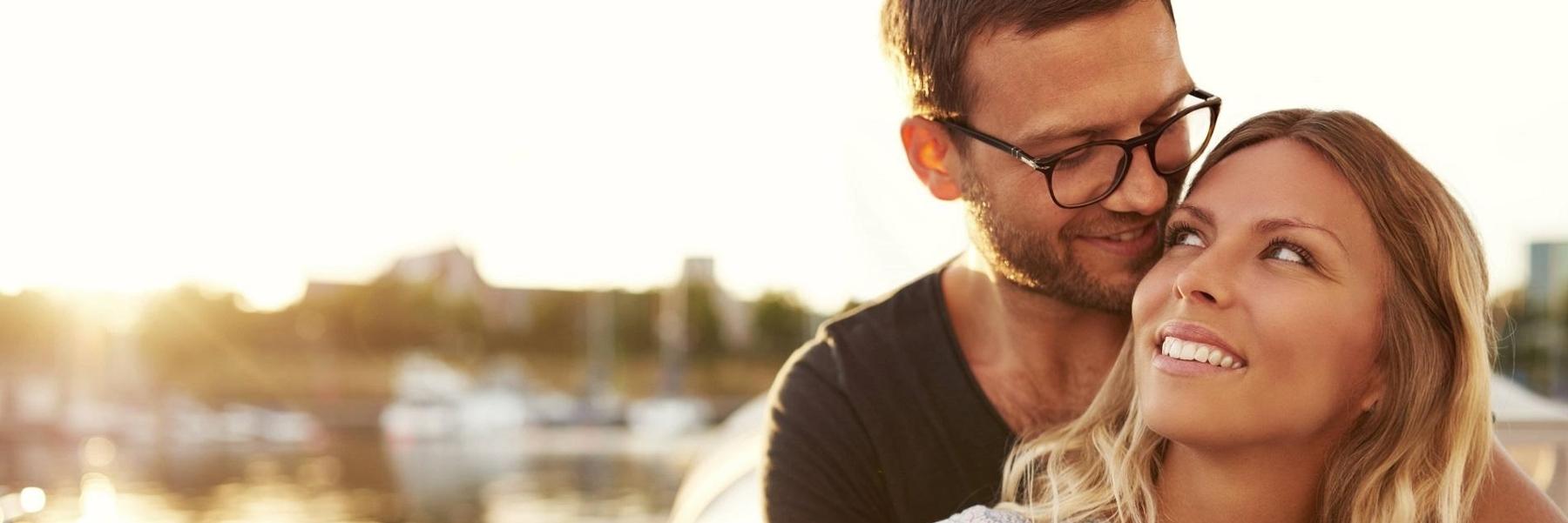 woman smiling at man with glasses